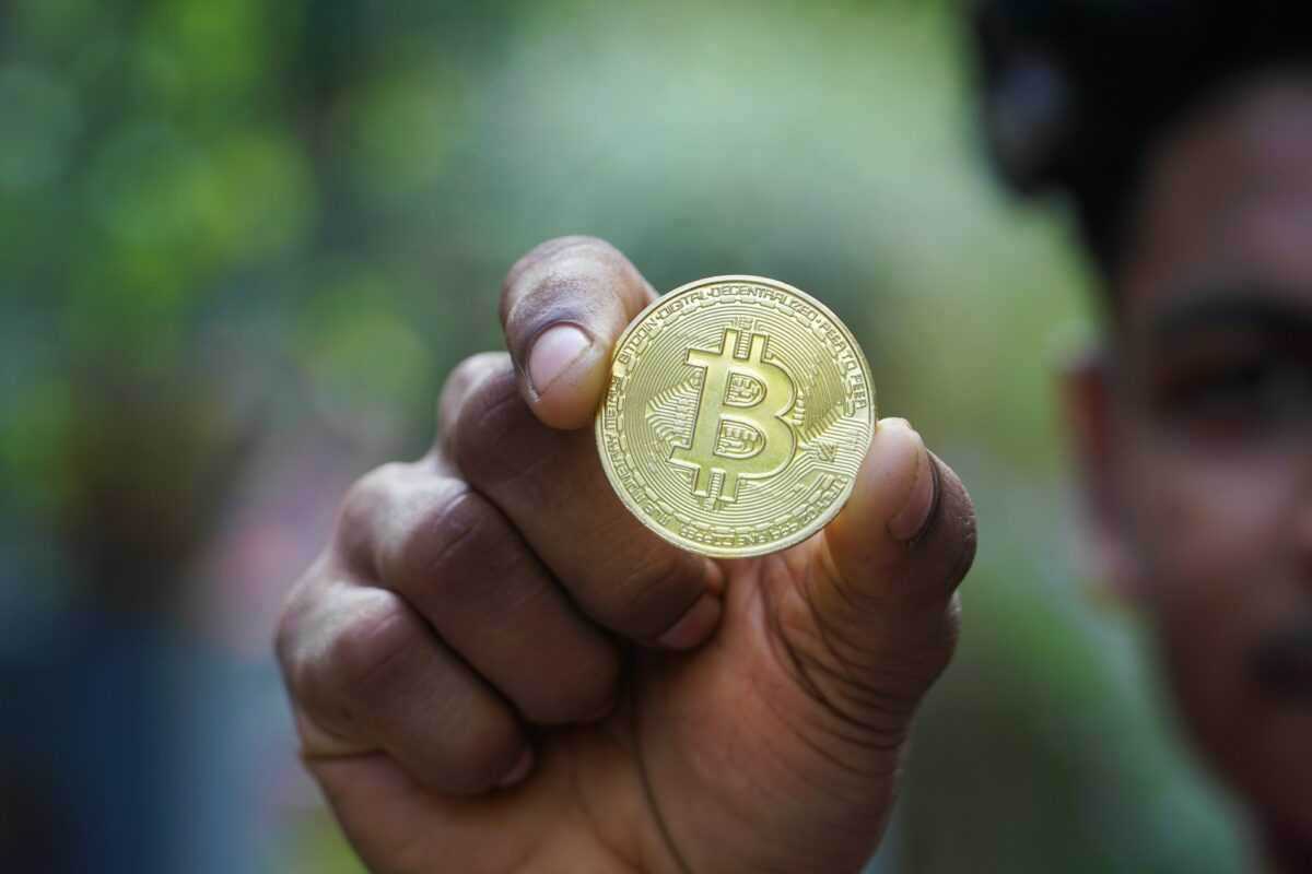 a man holding a bit coin in his hand