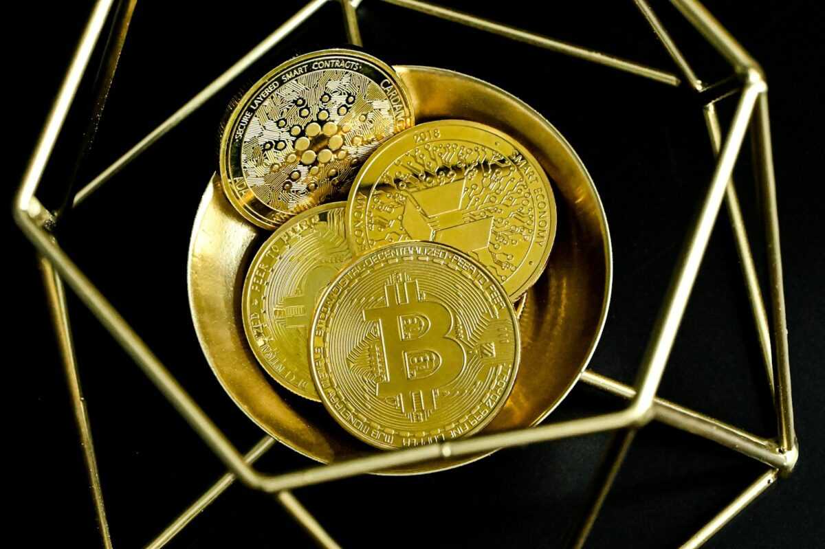 a golden bitcoin sitting on top of a gold plate