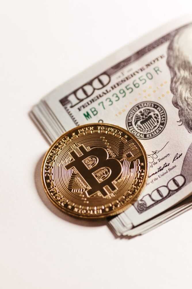 a bitcoin sitting on top of a pile of money