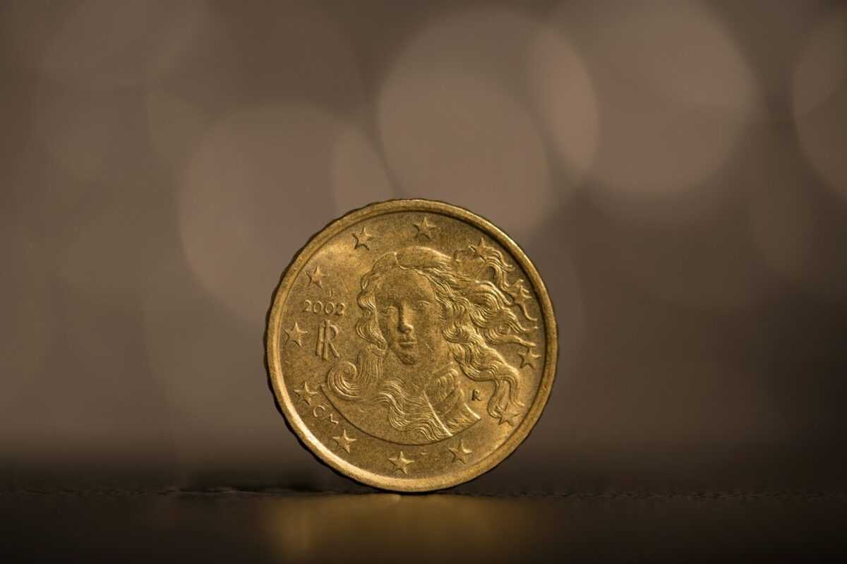 gold round coin on white surface